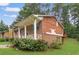 Rear view of a charming brick home featuring a covered front porch and mature landscaping at 115 Elizabeth Way, Ellenwood, GA 30294
