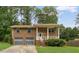 Charming brick home featuring a covered front porch, an attached two-car garage, and a well-manicured lawn at 115 Elizabeth Way, Ellenwood, GA 30294