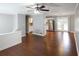View of open floor plan with hardwood floors, ceiling fan, and gray walls connecting living room to kitchen at 115 Elizabeth Way, Ellenwood, GA 30294