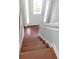 View looking down staircase featuring hardwood steps, white handrail, white door, and a window at 115 Elizabeth Way, Ellenwood, GA 30294