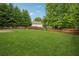 Expansive, fully fenced backyard featuring mature trees and lush green lawn at 2040 Village Green Dr, Fairburn, GA 30213