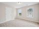 Bright, carpeted bedroom featuring two windows for natural light and a neutral color palette at 2040 Village Green Dr, Fairburn, GA 30213