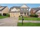Charming two-story home with a two-car garage, covered porch and a well-maintained lawn at 2040 Village Green Dr, Fairburn, GA 30213