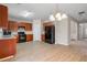 Bright, spacious kitchen featuring wooden cabinets, black appliances and wood-look flooring at 2040 Village Green Dr, Fairburn, GA 30213