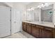Bright bathroom featuring double vanity, shower with tile surround, and neutral color palette at 4322 Braden Nw Ln, Kennesaw, GA 30144