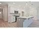 Modern kitchen featuring white cabinets, stainless steel appliances, gray island, and pendant lighting at 691 Sunstone Ln, Lawrenceville, GA 30043