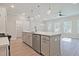 Open kitchen features stainless steel appliances, a large island with quartz counters, and pendant lighting at 691 Sunstone Ln, Lawrenceville, GA 30043
