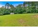 Lush green backyard with a storage shed surrounded by mature trees at 700 Walkingstick Dr, Douglasville, GA 30134
