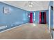 Large bedroom boasts blue walls, a vaulted ceiling and colorful curtains at 700 Walkingstick Dr, Douglasville, GA 30134