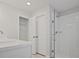 Bright bathroom featuring glass-enclosed shower, white subway tile, and storage at 905 Agate Ln, Lawrenceville, GA 30043