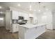 Bright kitchen features an island with pendant lights and modern appliances and gray backsplash at 905 Agate Ln, Lawrenceville, GA 30043