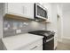 Modern kitchen with stainless appliances, gas cooktop, and grey subway tile at 905 Agate Ln, Lawrenceville, GA 30043