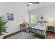 Bedroom features hardwood floors, a ceiling fan, a desk and natural light from large window at 173 Brush Creek Ct, Stockbridge, GA 30281