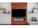 Cozy living room featuring a modern fireplace and entertainment center, complemented by floating shelves at 173 Brush Creek Ct, Stockbridge, GA 30281
