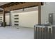 Modern garage door with sleek windows, plus an AC unit and exterior electrical box at 177 Brush Creek Ct, Stockbridge, GA 30218