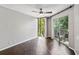 Spacious bedroom with hardwood floors, a ceiling fan, and balcony with greenery views at 244 13Th Ne St # 302, Atlanta, GA 30309