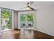 Bedroom with hardwood floors, ceiling fan, balcony access, and large window with tree views at 244 13Th Ne St # 302, Atlanta, GA 30309