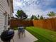 Backyard with patio area, grill, outdoor seating, grass and a wood fence at 5715 Radford Loop # 15, Fairburn, GA 30213