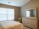 Bedroom features a large dresser with mirror, window, and neutral colored walls at 5715 Radford Loop # 15, Fairburn, GA 30213