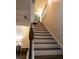 Carpeted staircase with wood railing leads to the upper level, lit with modern ceiling lights at 5715 Radford Loop # 15, Fairburn, GA 30213