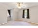 Bedroom features neutral walls, carpet, and ceiling fan, lit by natural light from two windows at 98 Little John Way, Douglasville, GA 30134