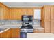 This well-equipped kitchen features wood cabinets, a gas range, an integrated microwave and solid surface counters at 98 Little John Way, Douglasville, GA 30134