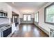 Open-concept living area with hardwood floors, wainscoting, and modern kitchen access at 1497 Rogers Ave, Atlanta, GA 30310