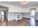 Cozy living room featuring a classic brick fireplace, hardwood floors, and entry to adjacent rooms at 1497 Rogers Ave, Atlanta, GA 30310