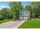 Charming two-story home featuring a blue exterior, landscaped yard, and two-car garage at 3450 Saddleton Way, Douglasville, GA 30134