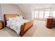Bedroom with neutral walls and carpeting, and an ornate, wood-trimmed bed frame at 3500 Parkwood Hills Ct, Snellville, GA 30078