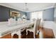 Formal dining room featuring a large white table, elegant chairs, hardwood floors, and stylish decor at 3500 Parkwood Hills Ct, Snellville, GA 30078