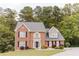Beautiful two-story brick home with classic design elements, a well-manicured lawn, and mature trees at 3500 Parkwood Hills Ct, Snellville, GA 30078