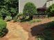 Landscaped backyard featuring stone path, retaining wall, and mature trees and plantings at 40 Dunwoody Springs Dr, Atlanta, GA 30328