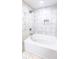 Bright bathroom featuring white marbled walls, a sleek bathtub, and modern fixtures at 6494 Bimini Dr, Forest Park, GA 30297