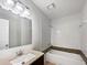 Bright bathroom featuring a large mirror, single sink vanity, and a bathtub with white tile and mosaic accent border at 8332 Mountain Pass, Riverdale, GA 30274
