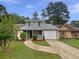 Charming home with a well-maintained front yard and a driveway leading to an attached garage at 8332 Mountain Pass, Riverdale, GA 30274