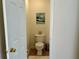 Neutral colored half bath featuring a white toilet, ceramic tile flooring, and a painting on the wall at 1055 Havenstone Walk, Lawrenceville, GA 30045
