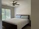 Bedroom features a ceiling fan, a large window with blinds, and a queen-size bed at 1055 Havenstone Walk, Lawrenceville, GA 30045