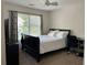Bedroom featuring a bed, desk, ceiling fan and a large window for natural light at 1055 Havenstone Walk, Lawrenceville, GA 30045