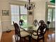 A bright dining room with a glass-top table and wood floors at 1055 Havenstone Walk, Lawrenceville, GA 30045