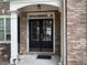 Elegant double front doors with glass panels, framed by white columns and brick facade at 1055 Havenstone Walk, Lawrenceville, GA 30045