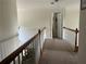 Hallway with carpet flooring, wood railing, and trim, featuring access to other rooms of the house at 1055 Havenstone Walk, Lawrenceville, GA 30045