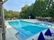 Community pool with clear blue water and umbrellas, surrounded by trees for a refreshing outdoor experience at 1055 Havenstone Walk, Lawrenceville, GA 30045