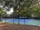 Outdoor tennis court surrounded by green trees behind a black fence at 1055 Havenstone Walk, Lawrenceville, GA 30045