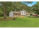 Spacious backyard with lush lawn and mature trees, offering ample room for outdoor activities at 135 Buckhurst Way, Atlanta, GA 30349
