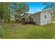 View of the home's exterior, including the deck, back yard and mature trees at 135 Buckhurst Way, Atlanta, GA 30349