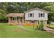 Charming split-level home featuring a brick facade, covered porch, and well-maintained lawn at 135 Buckhurst Way, Atlanta, GA 30349