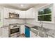 Modern kitchen with stainless steel appliances, granite countertops, and a stainless steel farmhouse sink at 135 Buckhurst Way, Atlanta, GA 30349