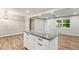Kitchen island with granite countertops and modern cabinetry, with a view of the main entry at 135 Buckhurst Way, Atlanta, GA 30349