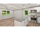 Bright open kitchen with stainless appliances and granite countertops, connecting to a dining and living area at 135 Buckhurst Way, Atlanta, GA 30349